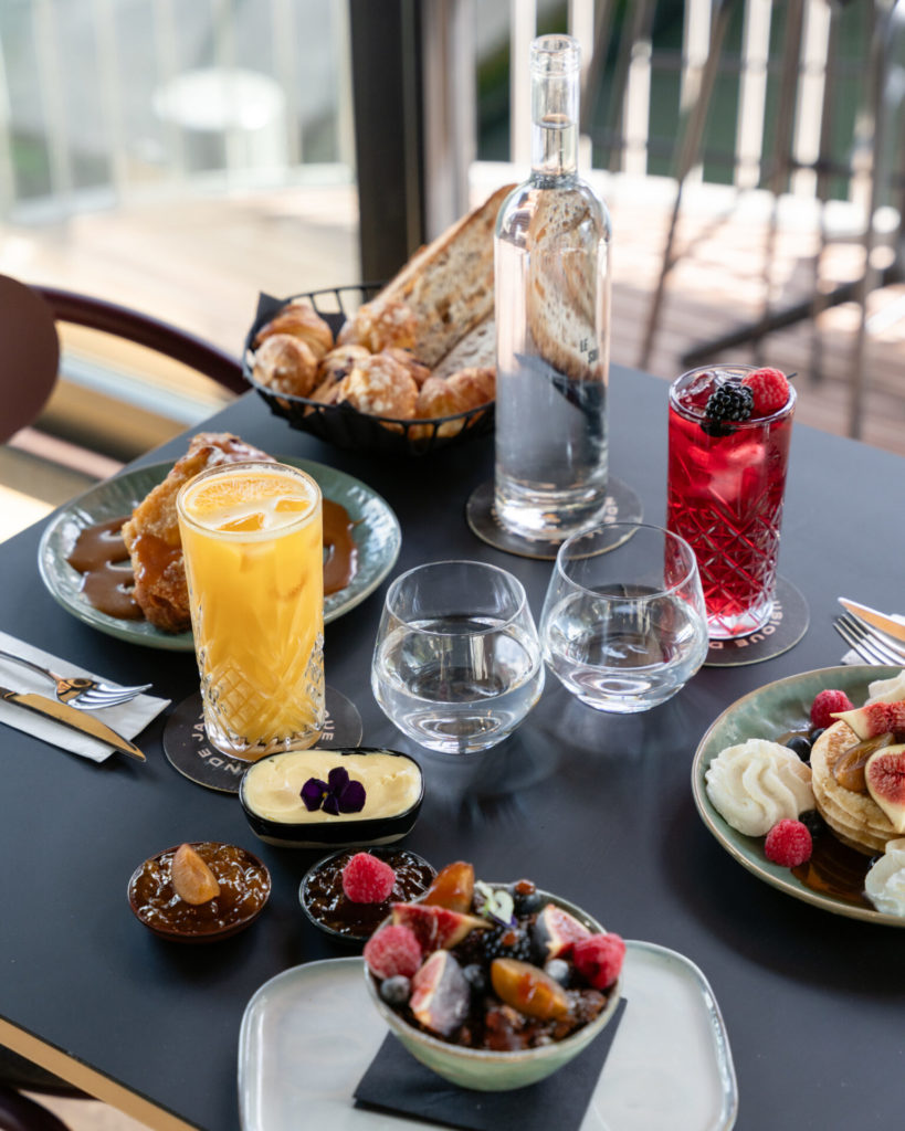 Fruits, pancakes, gateaux, confitures, pains et viennoiseries, jus d'orange, formant une partie du délicieux brunch proposé lors d'un concert sur une péniche à Paris.